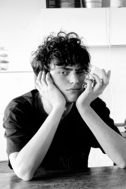 black and white pograph of a young man sitting in front of a window