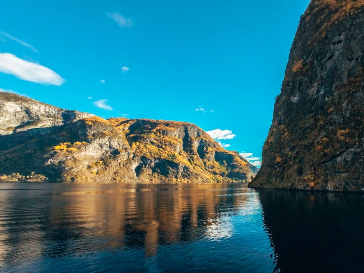 water floating on top of a mountain near a large cliff