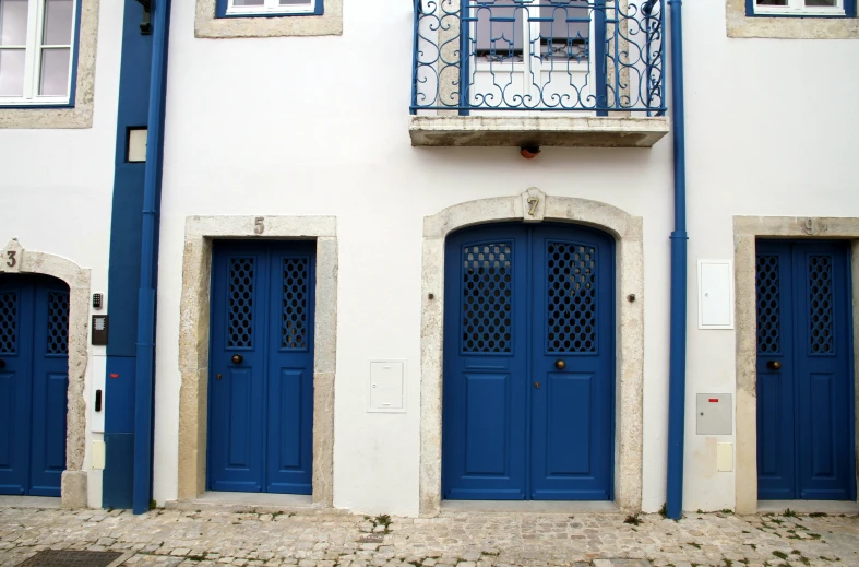 blue front doors and balcony with wrought iron railing