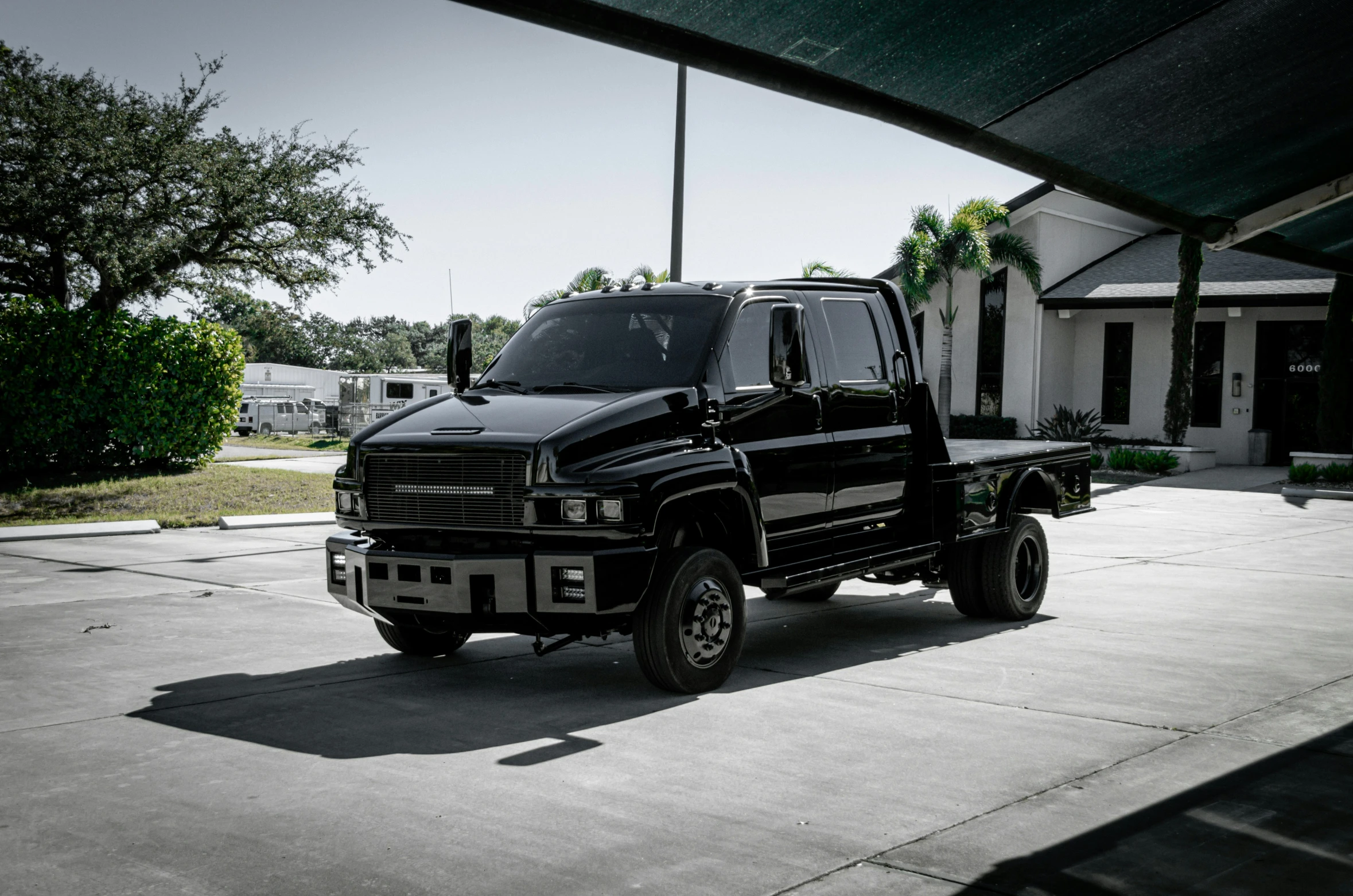 a black four wheeler parked on concrete next to a house