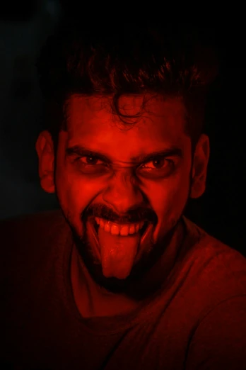 a close up of a man making weird faces and pulling off some kind of evil look