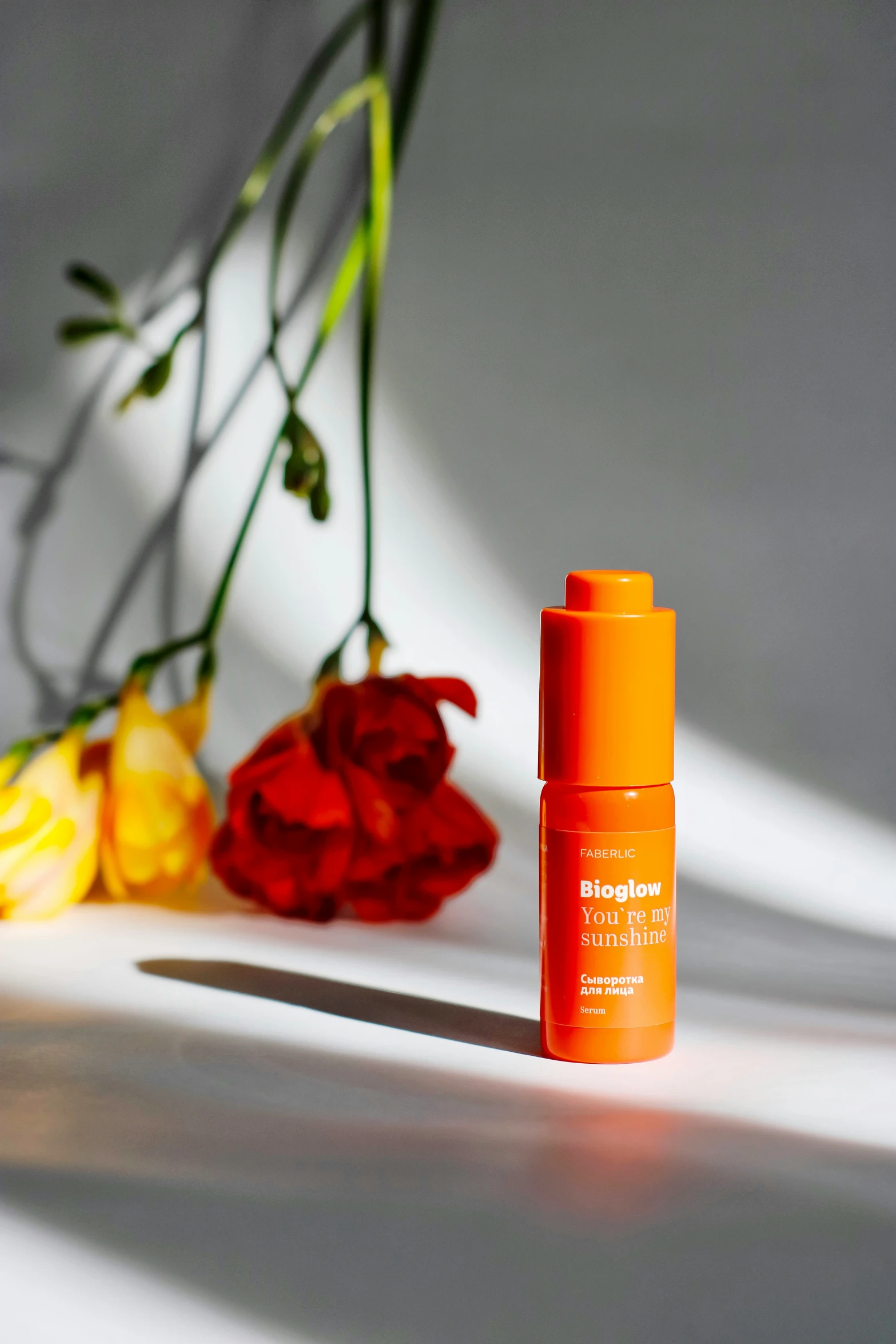 a bottle of vitamin c eye concentrate and red flowers