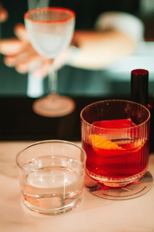 two glasses with liquid in them next to a wine glass