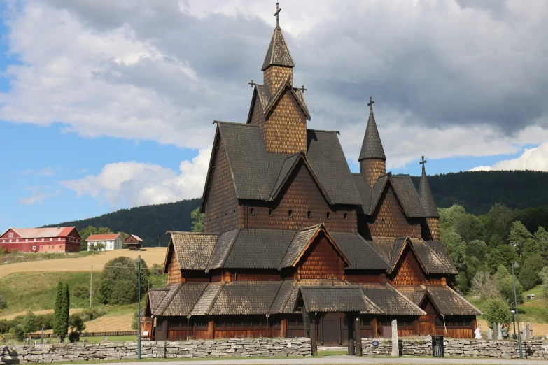 a tall wooden house with stone walls and roof