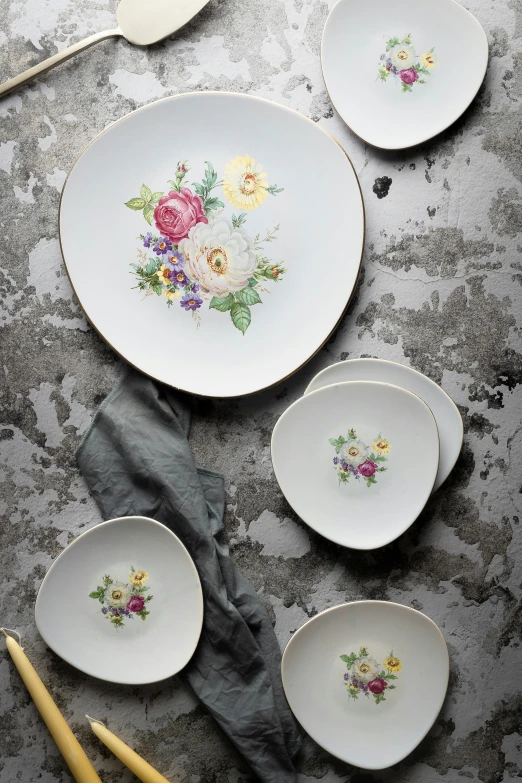 several plates with a flower pattern on them and a yellow fork