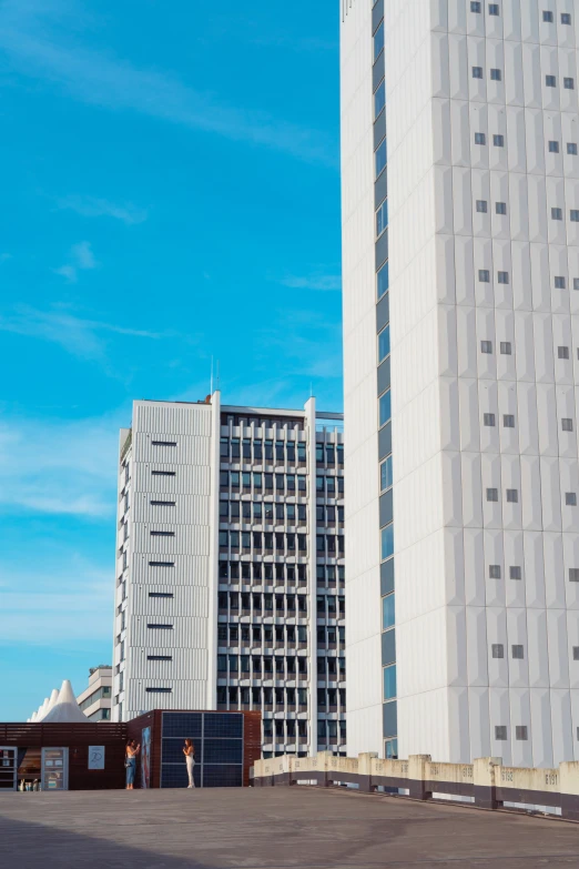 two large white buildings next to each other in front of blue sky