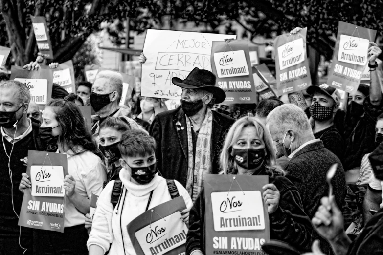 a large group of people holding up signs in black and white