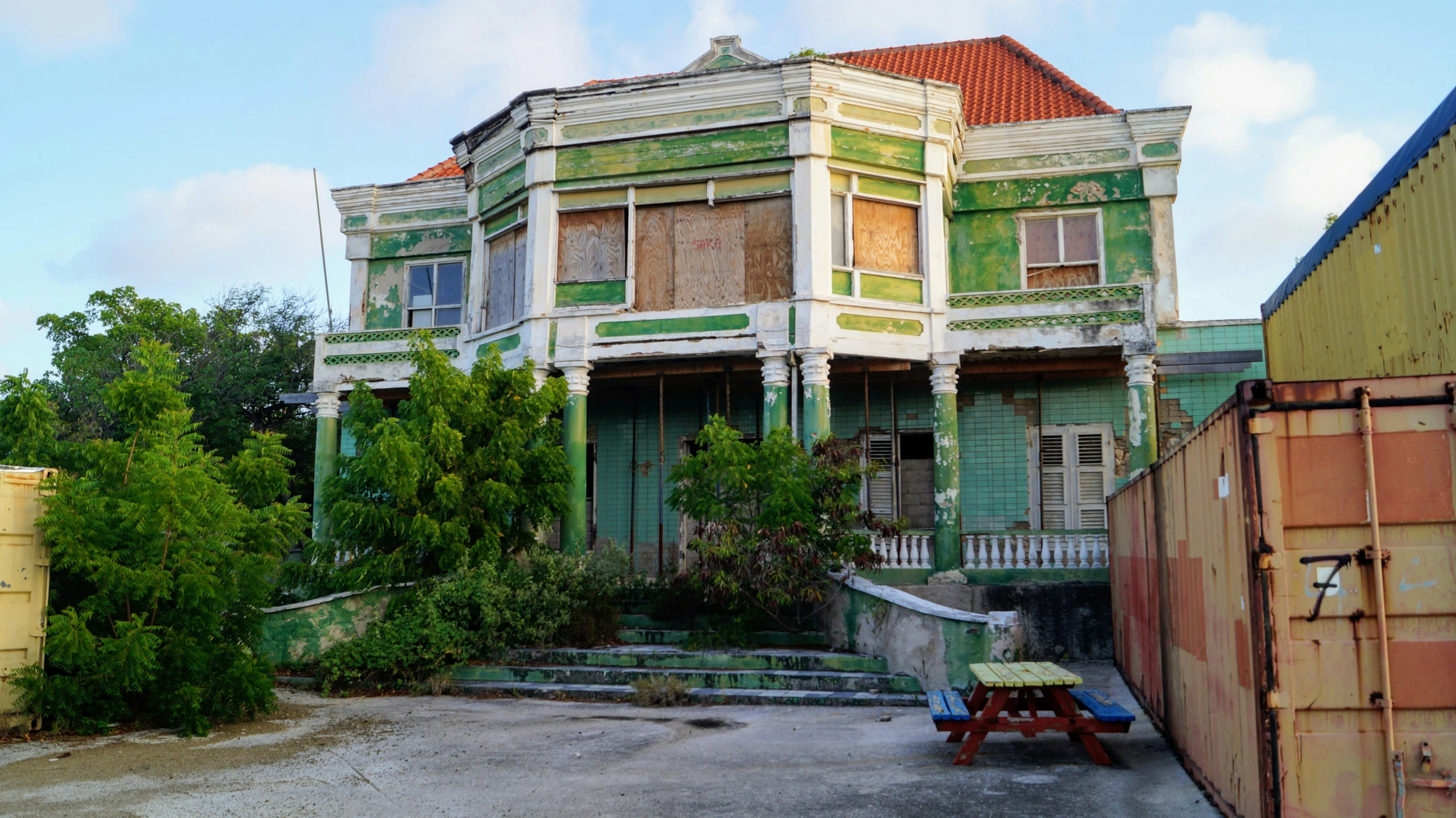 an abandoned green house with lots of paint