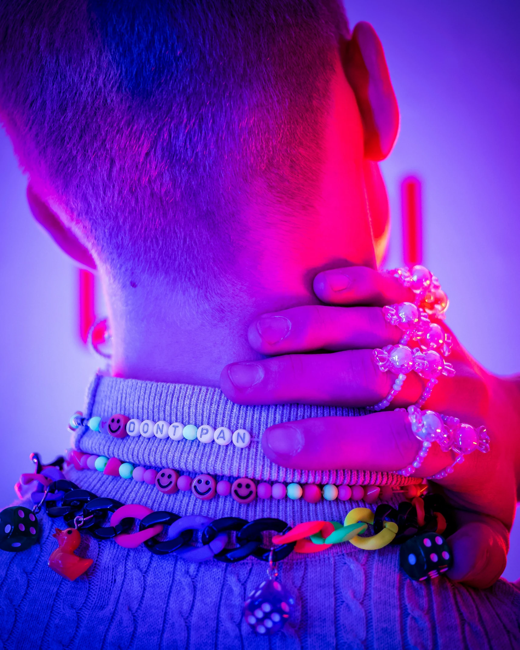 a young man with jewelry around his neck