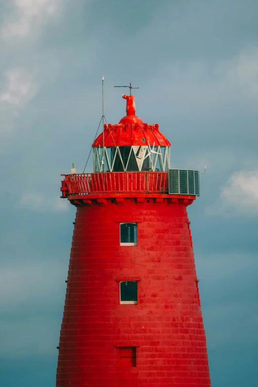 the front of a red light house at the beach