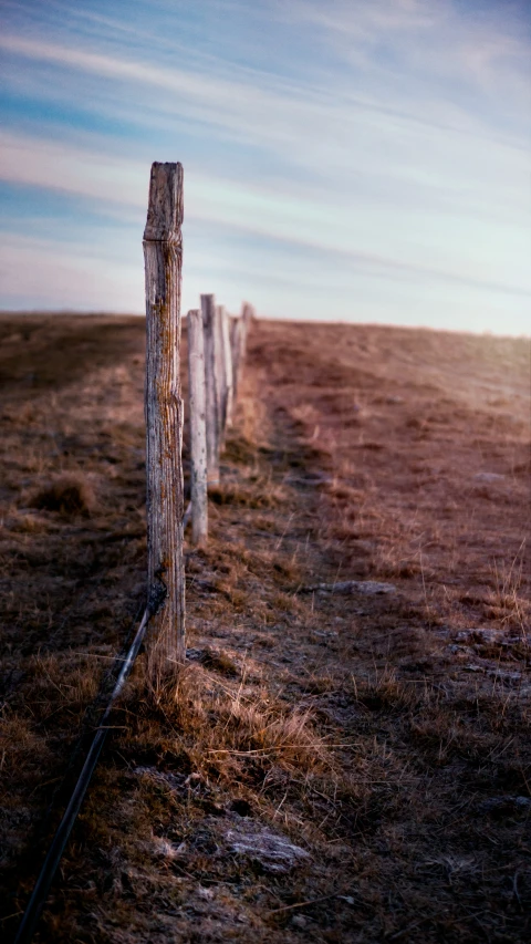 a po of a lonely fence at the end of a hill