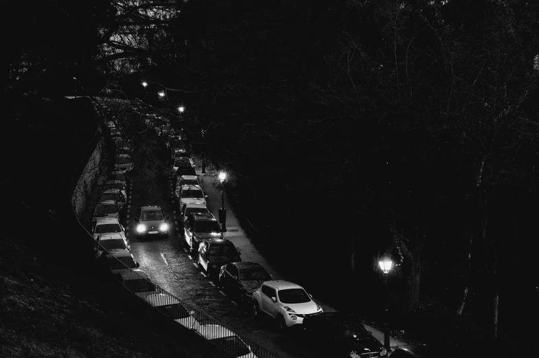 night scene showing multiple cars parked on a street in the dark