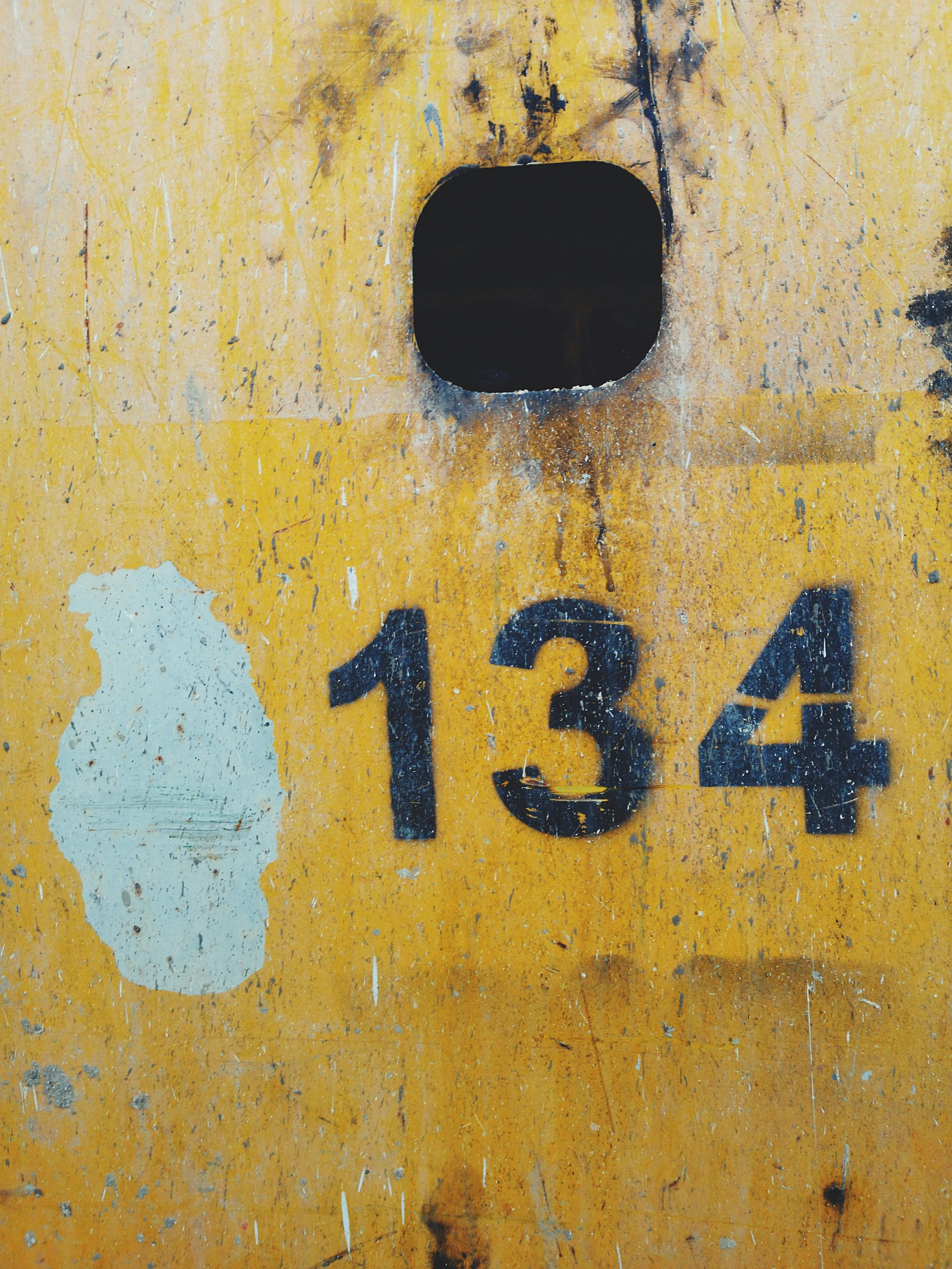 an old sign sitting next to some yellow walls