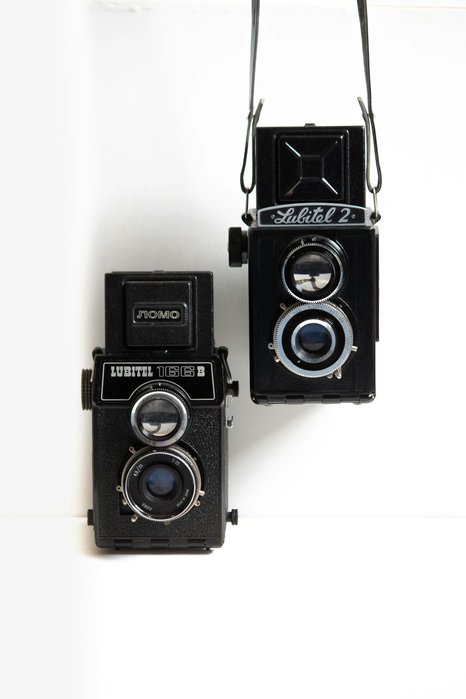 two old cameras hanging on the wall