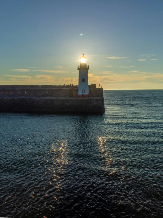 a lighthouse sitting on the side of a pier