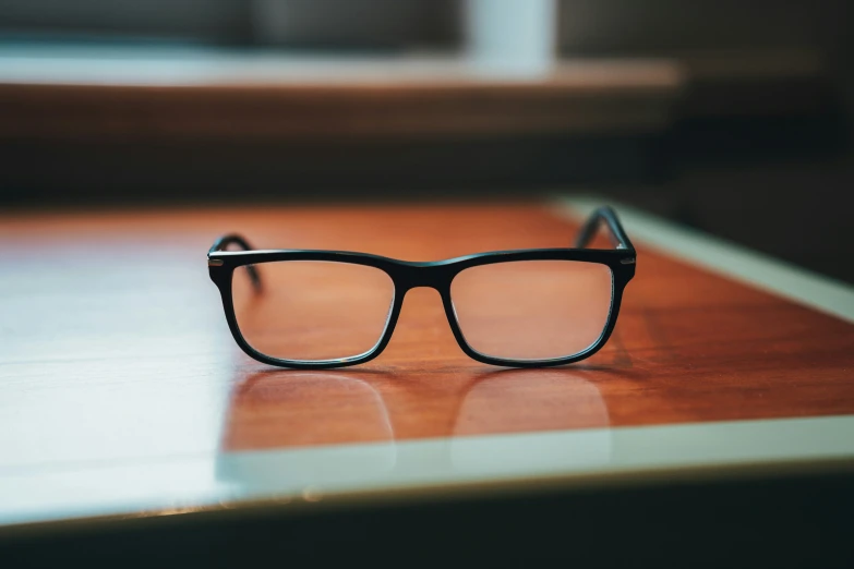 black glasses on top of a wooden table