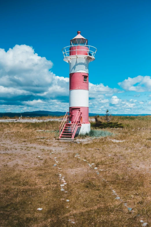 a very tall light house with a bright pink roof