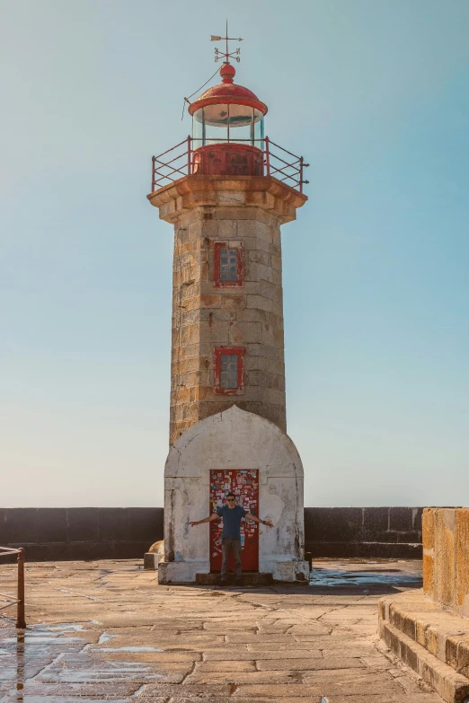 a small lighthouse surrounded by water and a blue sky