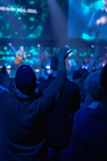 a crowd at a concert clapping their hands