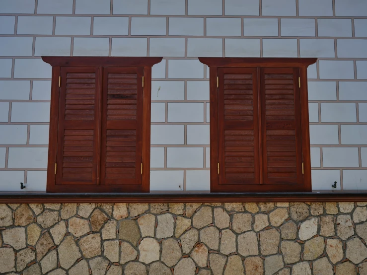 two open wooden doors sitting on top of a stone wall