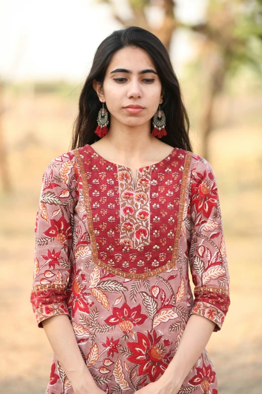 a woman wearing a red dress and large earrings