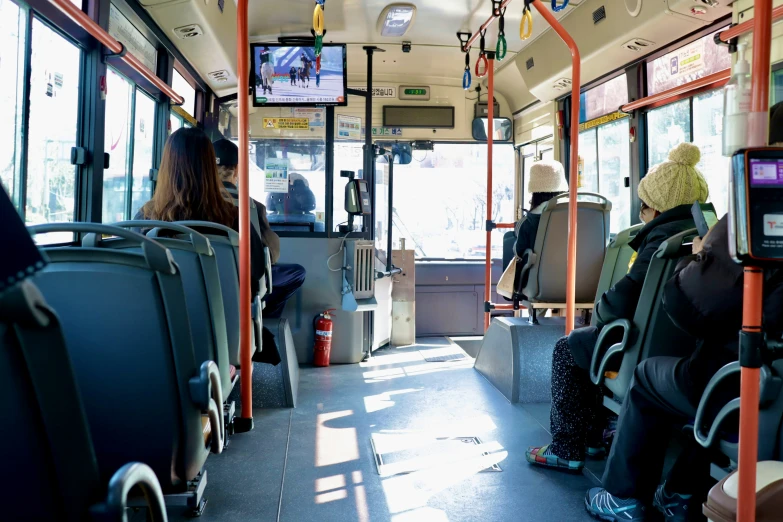 people are sitting inside a crowded bus and they have backpacks