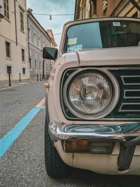 the front of an old vehicle parked in a street