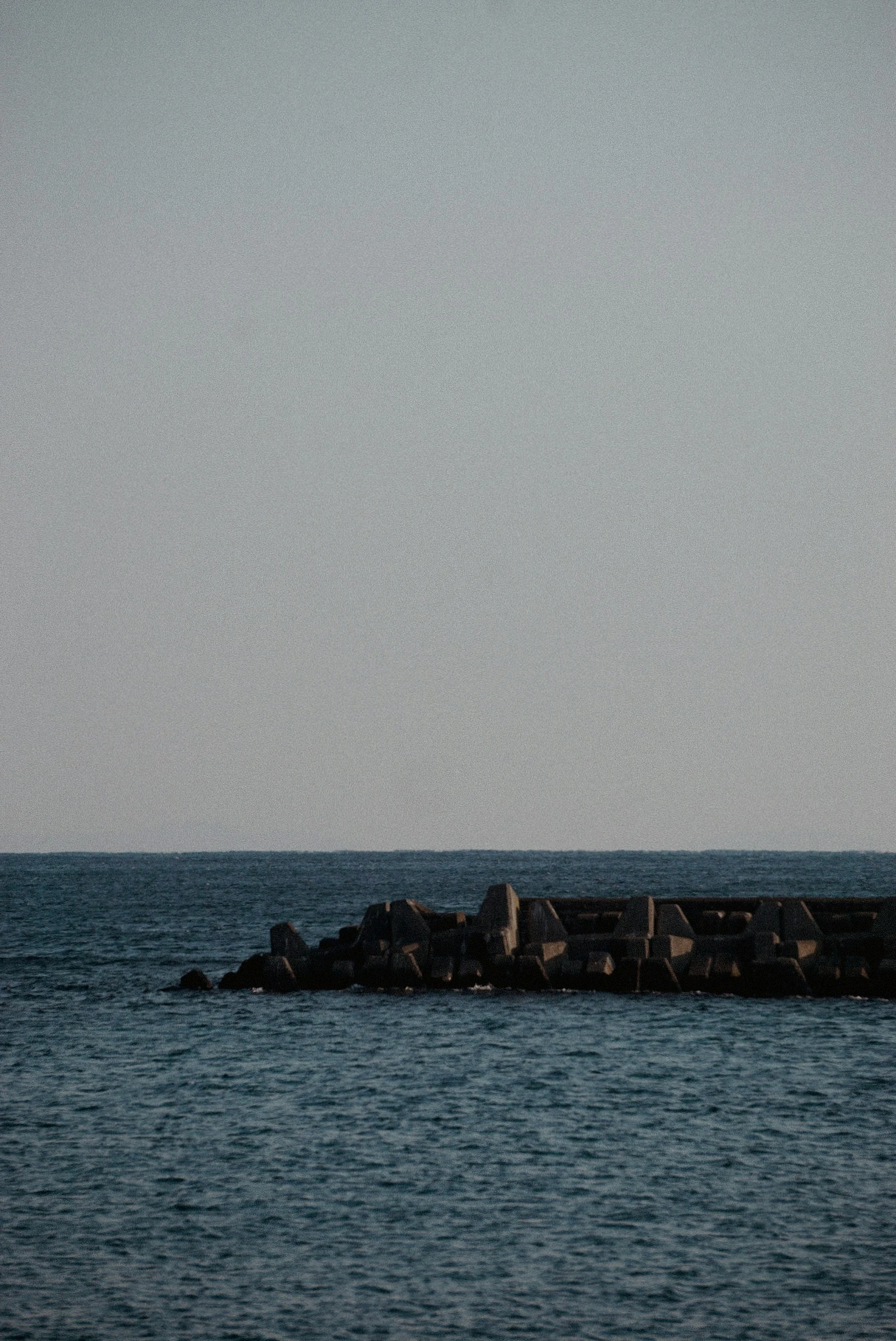 a long pier sitting in the middle of the ocean