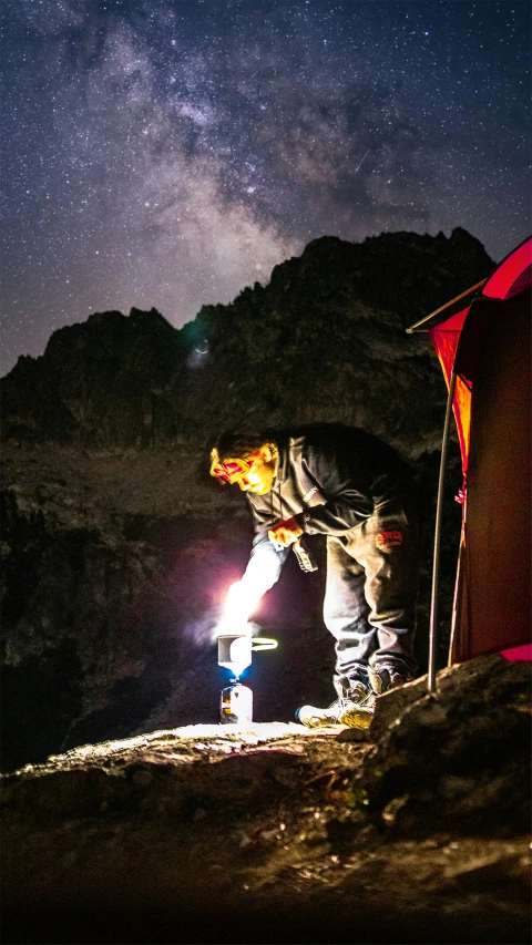 the man is working on soing outside of the tent