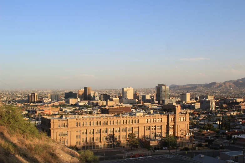 the city has several buildings in it and hills in the distance