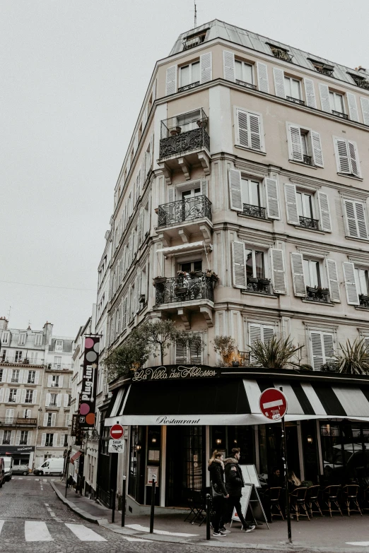 the building with black and white striped awnings is situated at the corner of a street