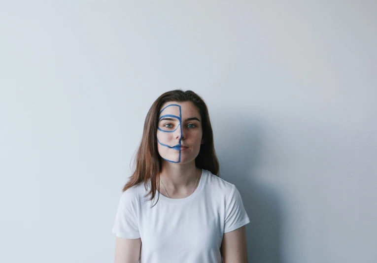 a woman wearing a taped face and painted lines in the middle