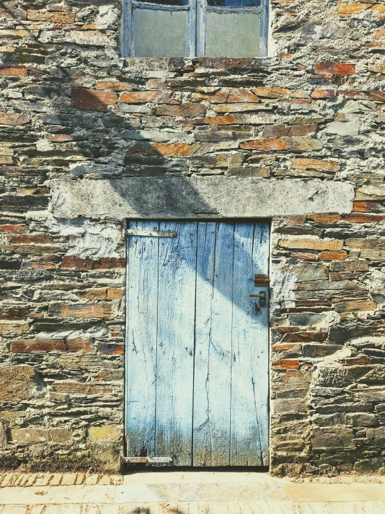 an old brick building with the door and windows painted blue