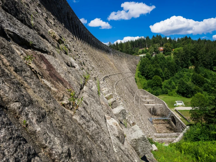 a very tall rock formation that is next to a wall