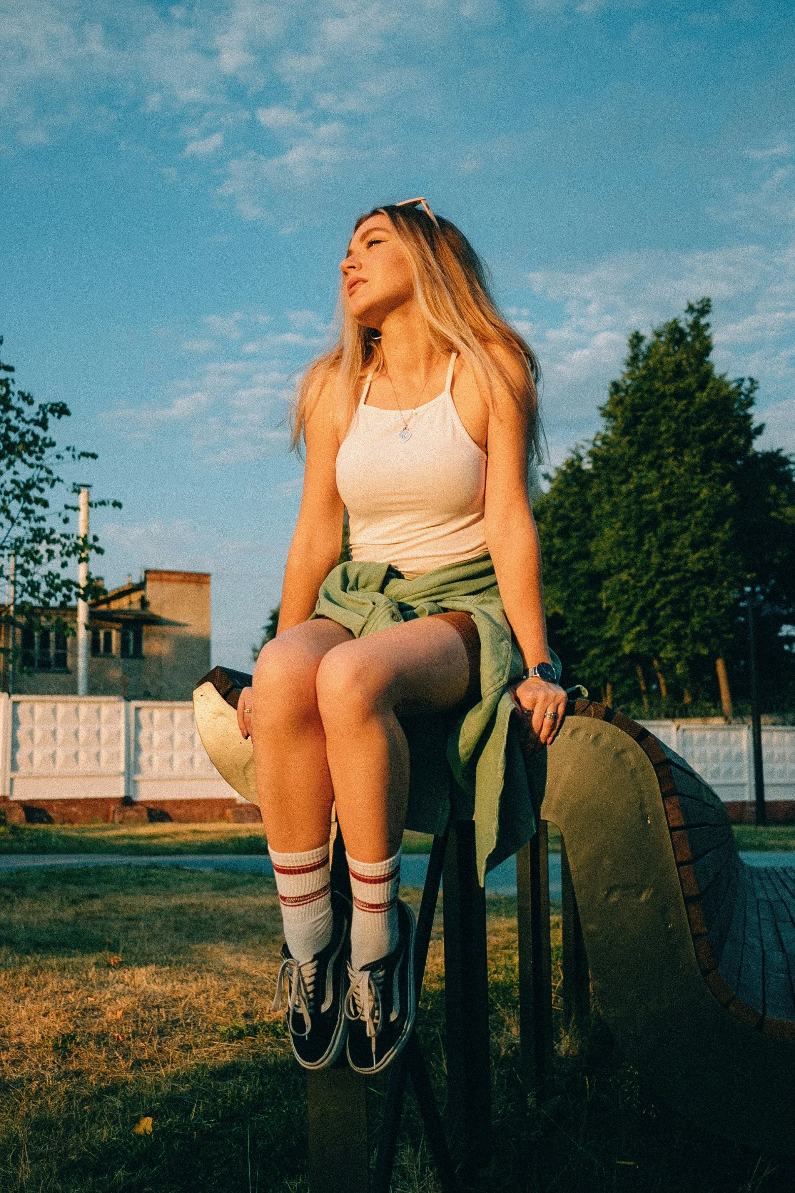 woman sitting on top of a luggage bag in the sun