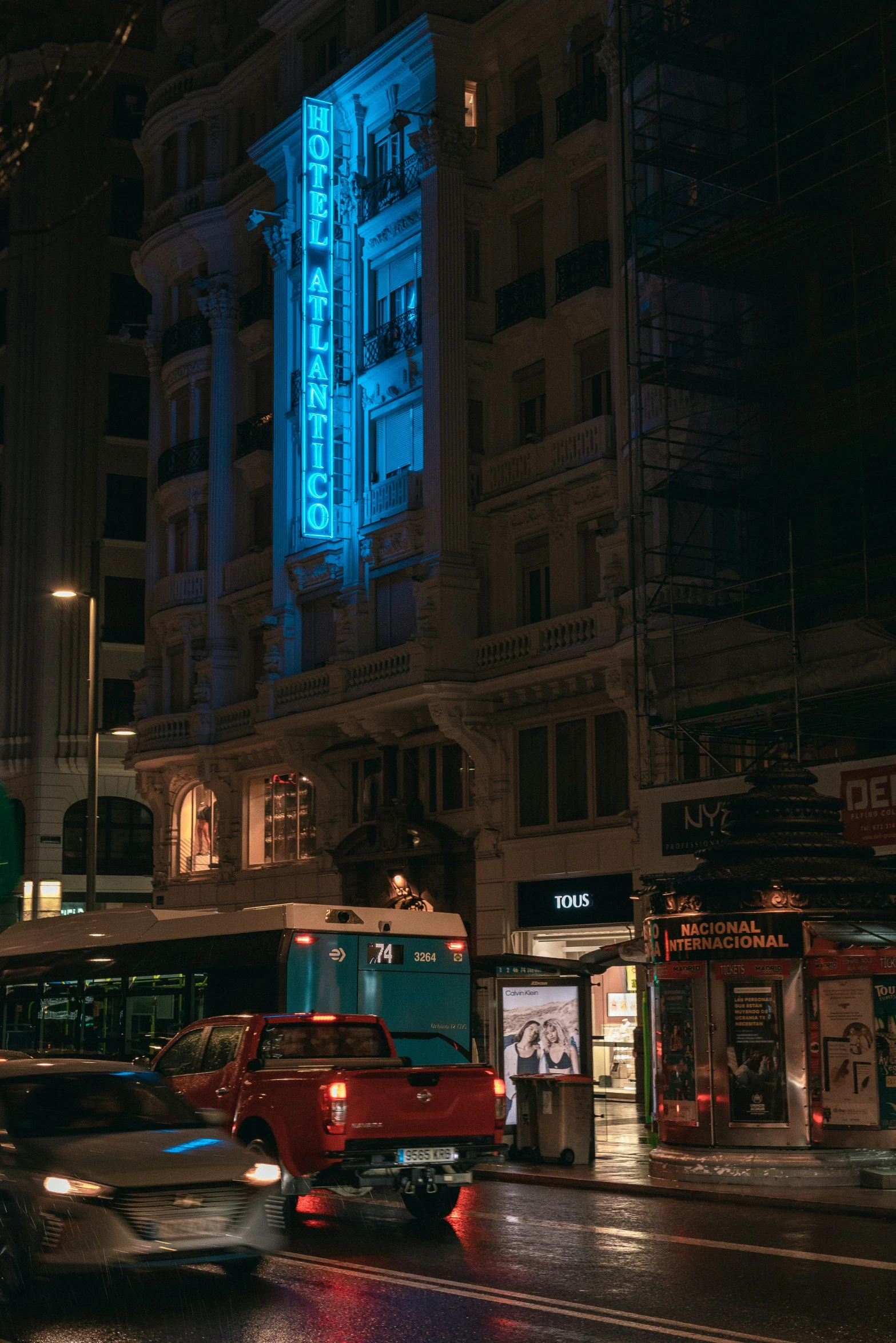 cars on a busy city street with an illuminated building in the background