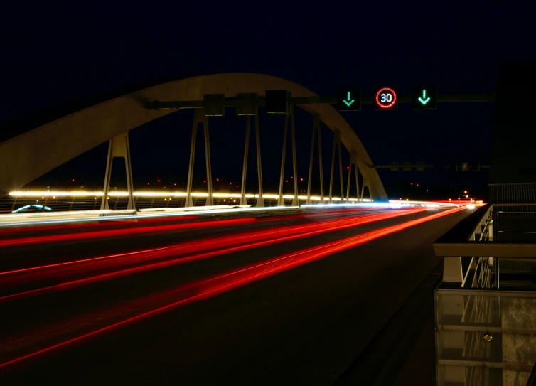 car lights streak down from the sky above a bridge