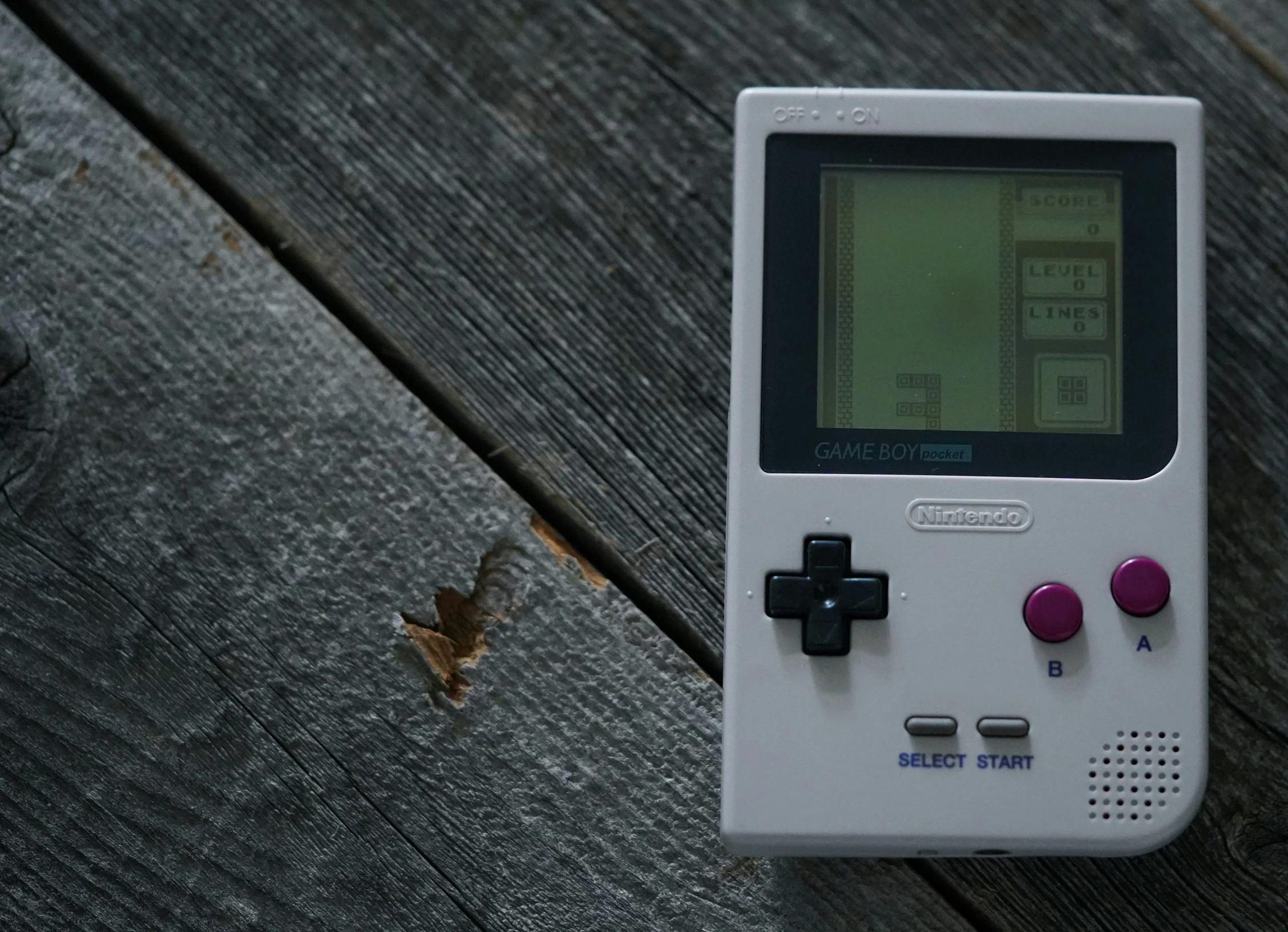 a gameboy sitting on top of a wooden table