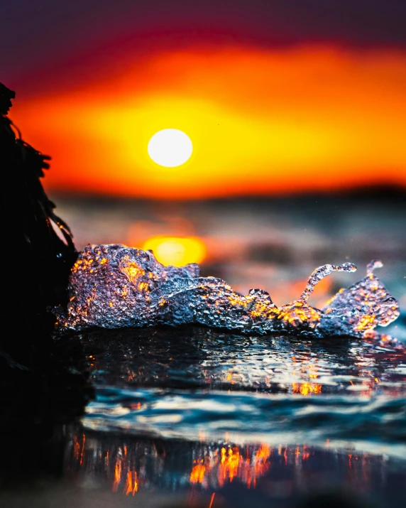 a sunrise with water splashing and a small wave