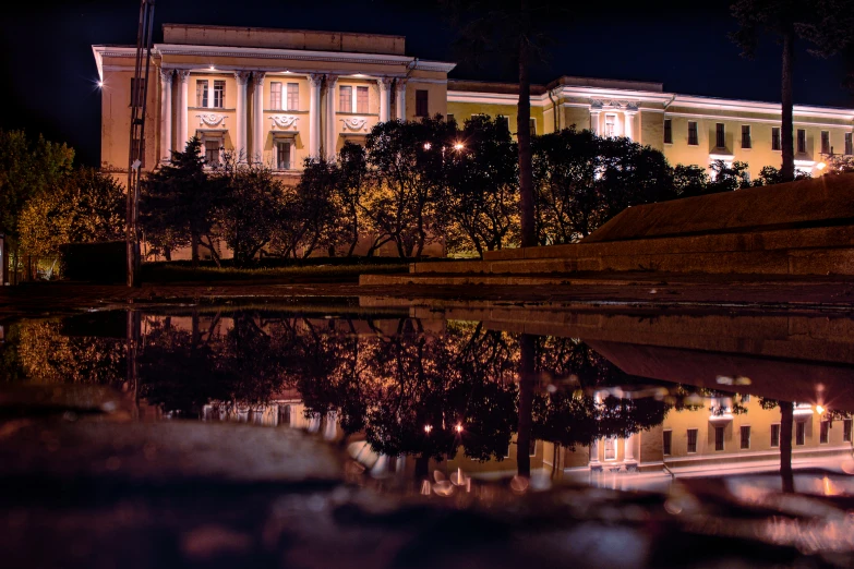 building reflected in the water with trees in front