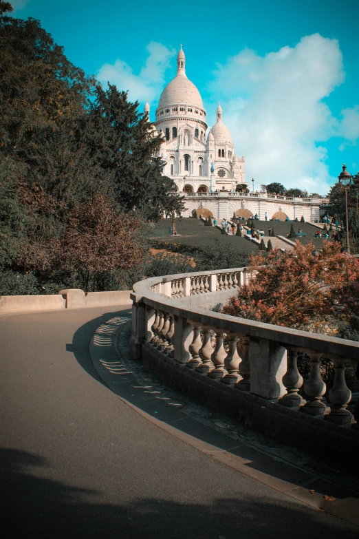 a large building with trees around it and a bridge to the other side