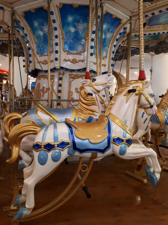 an amut park carousel with a blue and white striped horse