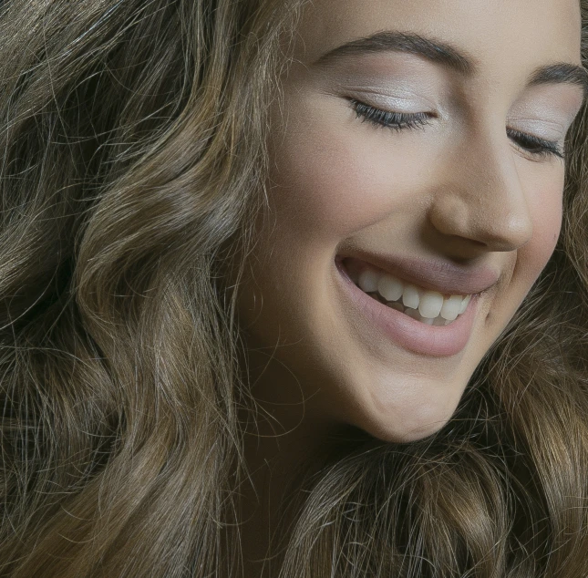 a beautiful woman smiling with a very long wavy hair