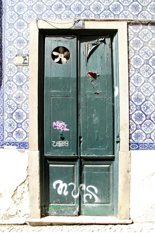 a door with graffiti is in front of a wall