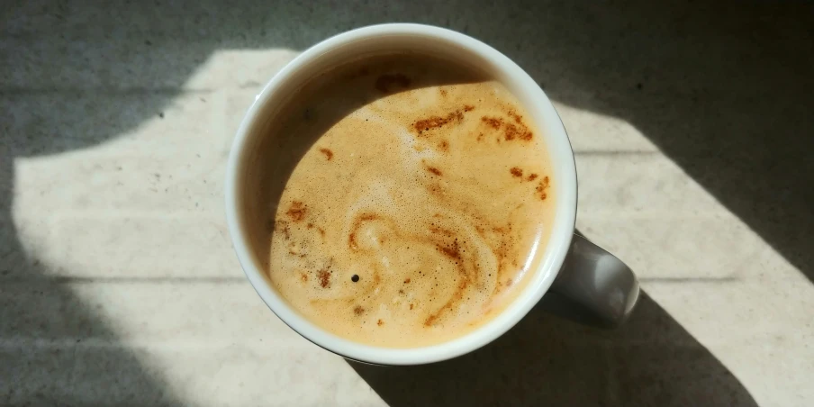 there is a cup of coffee with the top left half filled