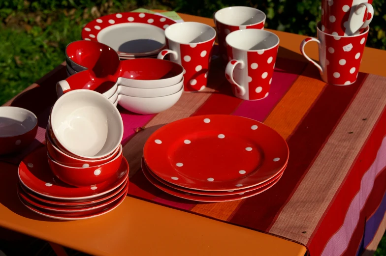 plates and cups sit on a table near red stripes