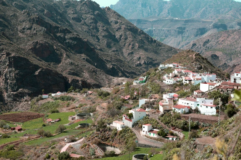 a mountain with houses near by on a road