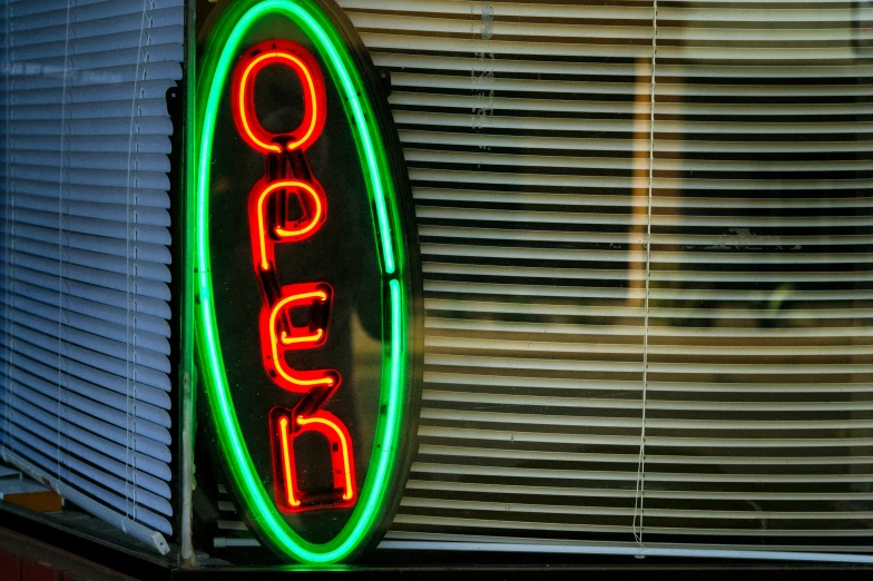 the neon sign says open in red and green