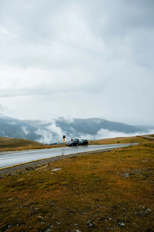 train traveling on an overcast day near a winding road