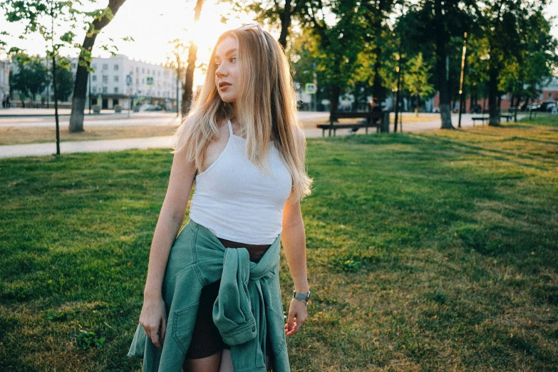 a girl in white shirt and green skirt posing